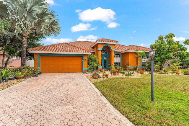 mediterranean / spanish house with a garage and a front yard