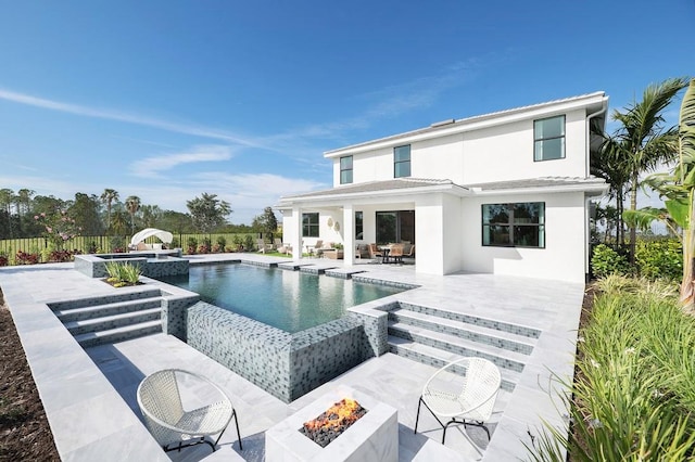 exterior space featuring an outdoor fire pit, a fenced in pool, and a patio