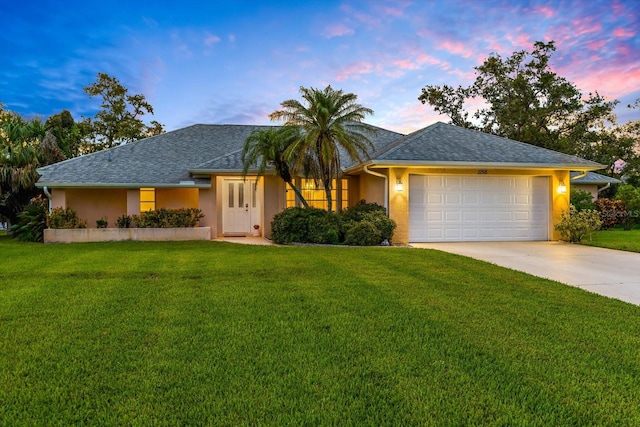 ranch-style house with a garage and a lawn