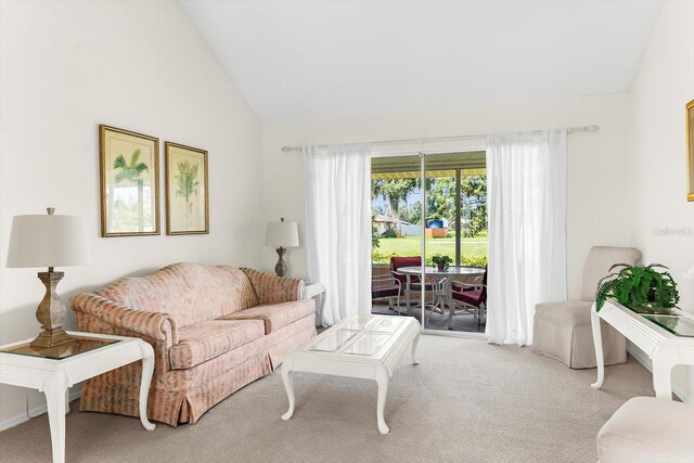 carpeted living room featuring high vaulted ceiling