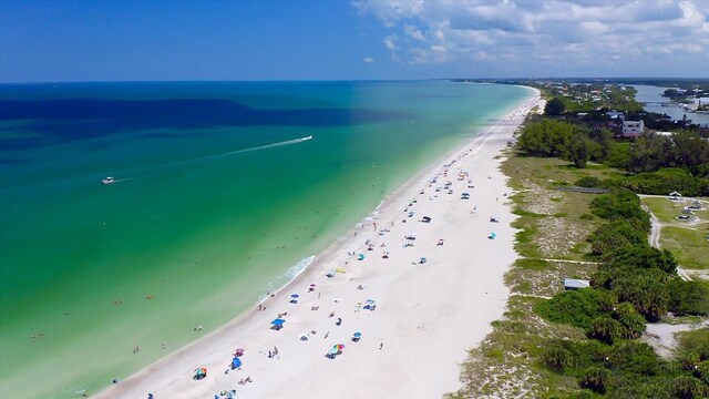 drone / aerial view featuring a water view and a view of the beach