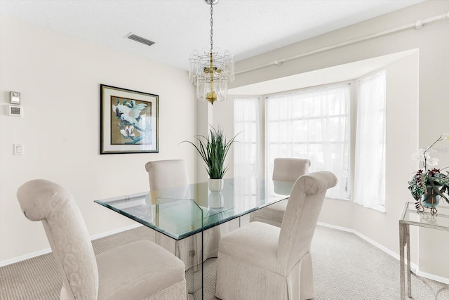 carpeted dining area featuring a chandelier