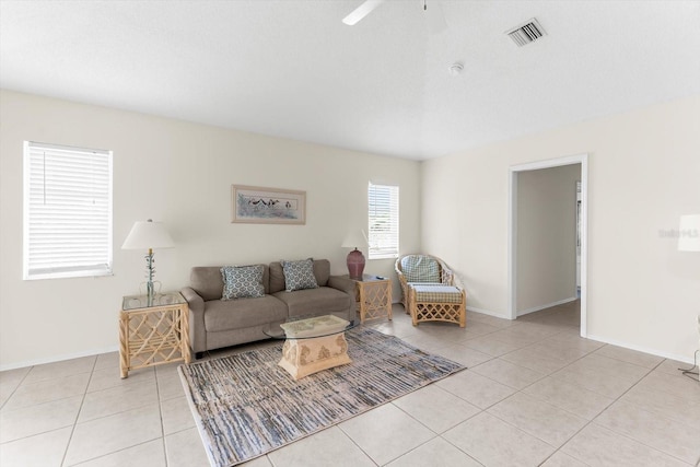 living area featuring light tile patterned floors, visible vents, and baseboards