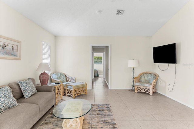 living area featuring baseboards, visible vents, and light tile patterned flooring