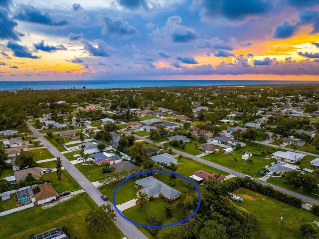 aerial view at dusk featuring a water view