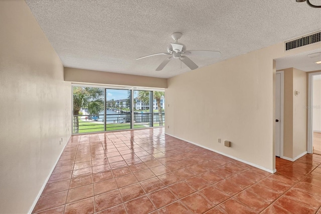 tiled spare room featuring a textured ceiling and ceiling fan