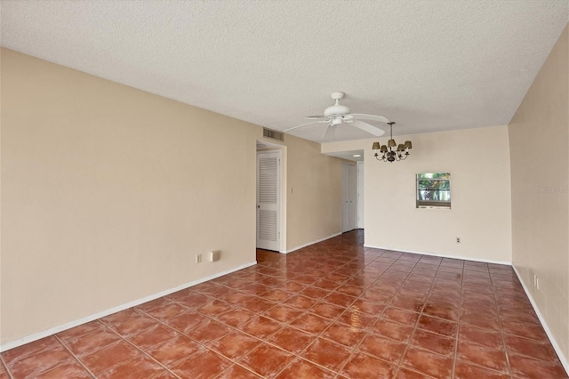 tiled spare room with a textured ceiling and ceiling fan with notable chandelier