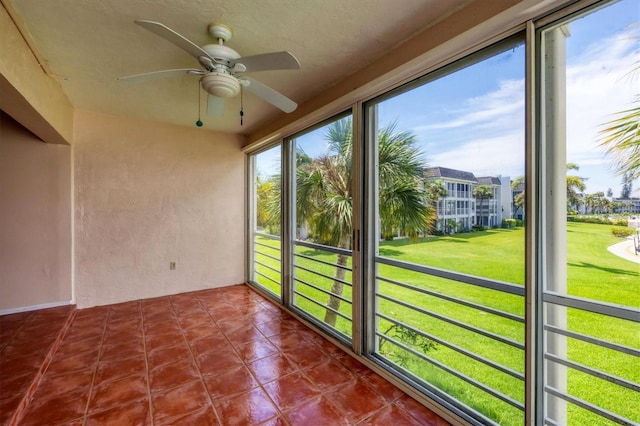 unfurnished sunroom featuring ceiling fan