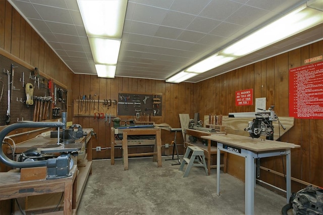 interior space featuring wooden walls, a workshop area, and concrete floors