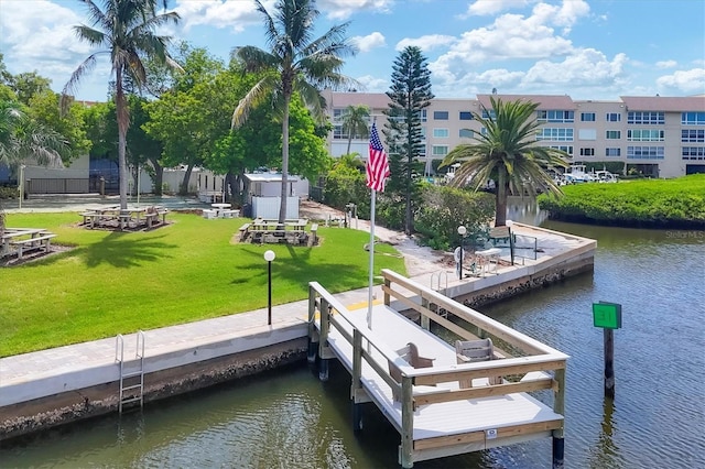 view of dock with a water view and a yard