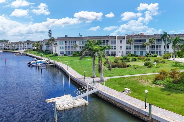 dock area with a lawn and a water view