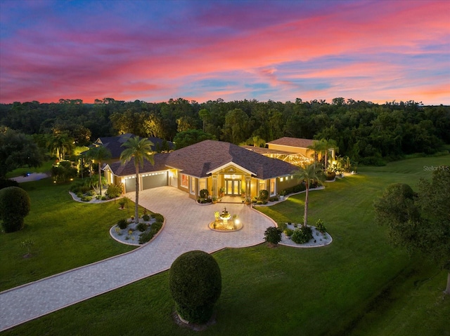 view of front of house with a garage and a yard