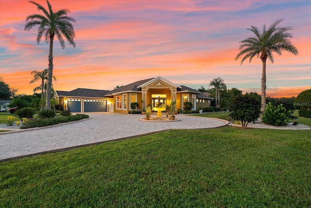 view of front of property featuring a garage and a lawn