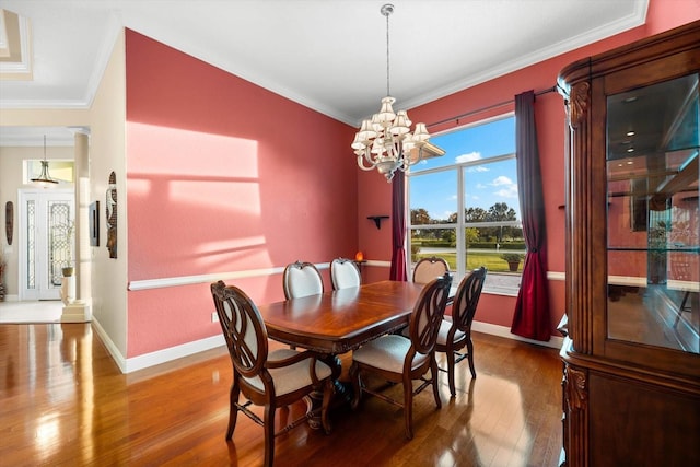 dining space featuring hardwood / wood-style floors, crown molding, and a notable chandelier