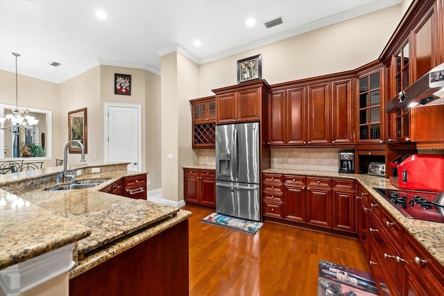 kitchen with dark hardwood / wood-style flooring, stainless steel fridge, sink, black electric stovetop, and pendant lighting