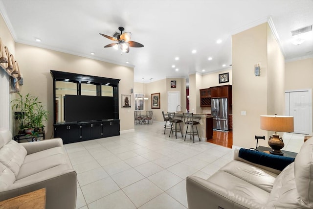 living room with ornamental molding, light tile patterned floors, and ceiling fan