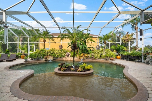 view of pool featuring glass enclosure, pool water feature, and a patio area