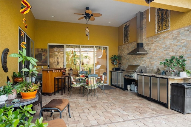 kitchen with ceiling fan and wall chimney range hood