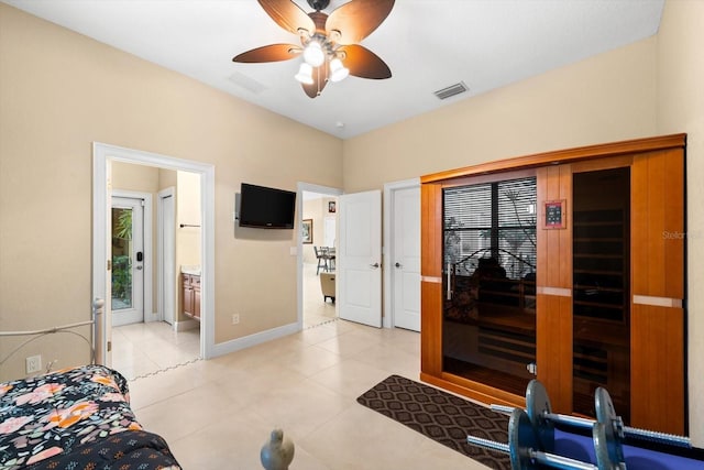 bedroom with multiple windows, connected bathroom, ceiling fan, and light tile patterned floors