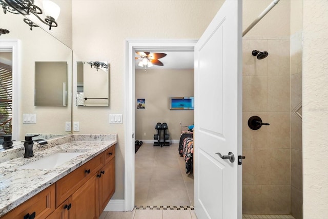 bathroom with ceiling fan, vanity, tiled shower, and tile patterned floors