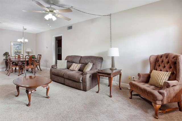 living room featuring light carpet and ceiling fan with notable chandelier