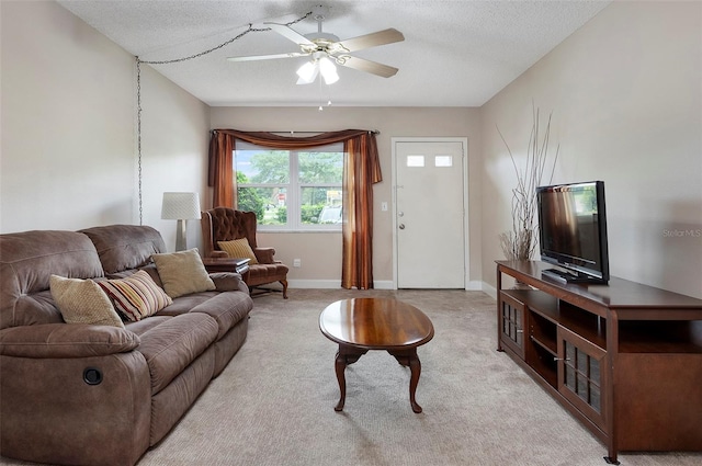 carpeted living room with ceiling fan and a textured ceiling