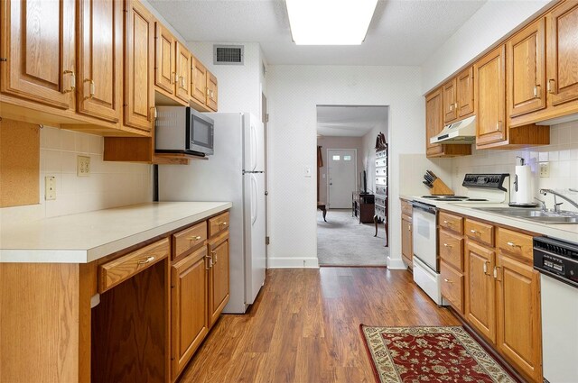 kitchen featuring sink, carpet flooring, backsplash, and white appliances