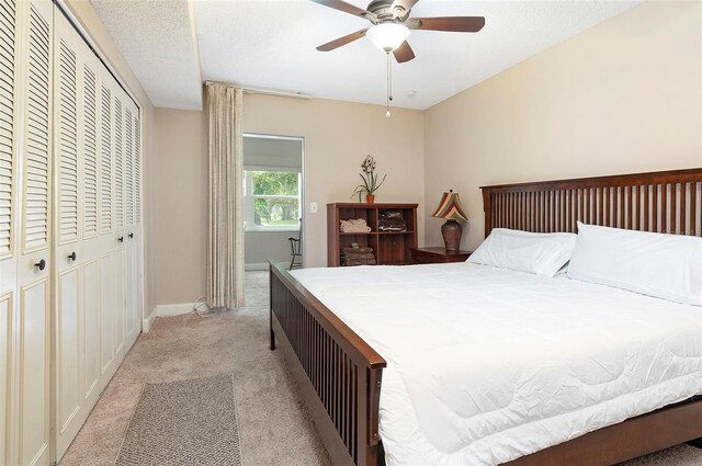 carpeted bedroom with a textured ceiling, a closet, and ceiling fan