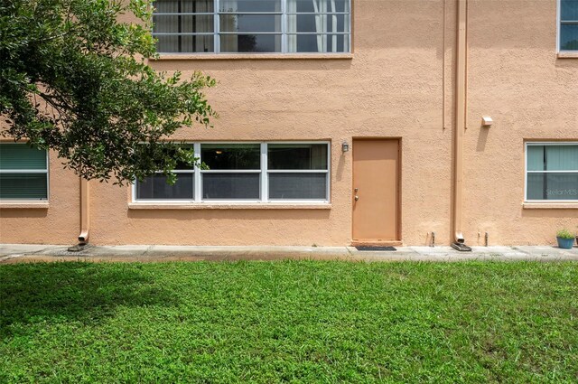 view of exterior entry with a lawn