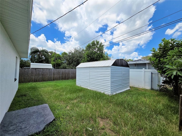 view of yard with a storage unit, an outdoor structure, and a fenced backyard