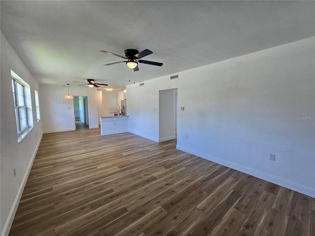 unfurnished living room with ceiling fan and hardwood / wood-style flooring