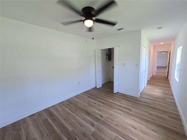 unfurnished bedroom featuring hardwood / wood-style floors, ceiling fan, and a closet