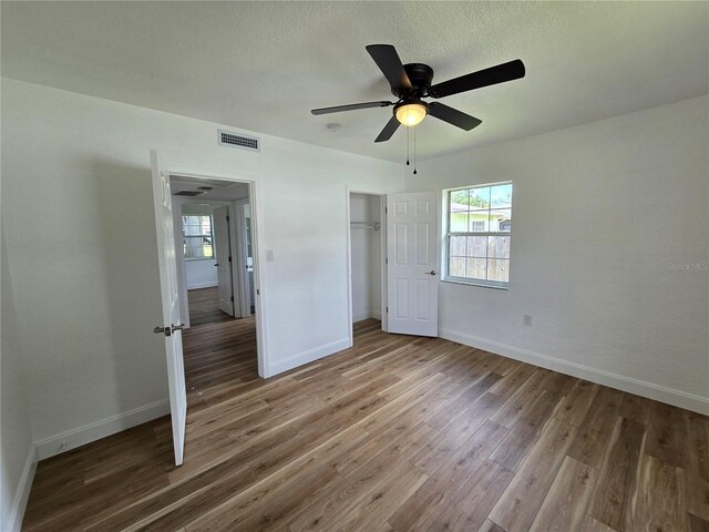 unfurnished bedroom with ceiling fan, hardwood / wood-style flooring, and a closet