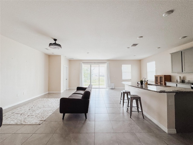 10827 Charlotte Dr, Parrish, FL 34219 - living area featuring light tile patterned flooring, baseboards, visible vents, and a textured ceiling