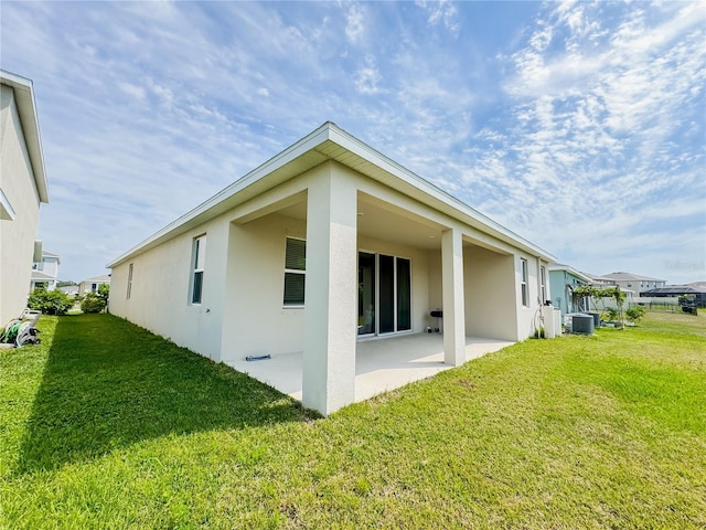 10827 Charlotte Dr, Parrish, FL 34219 - back of house featuring a patio, central AC unit, stucco siding, and a yard