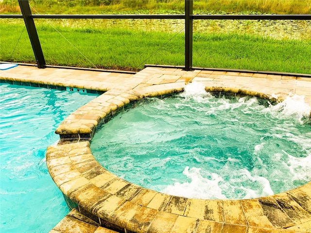 view of swimming pool featuring a hot tub