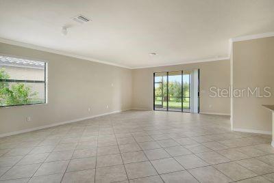 spare room with crown molding and light tile patterned floors