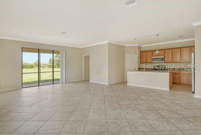 interior space featuring crown molding, pendant lighting, and light tile patterned floors