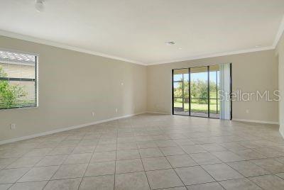 unfurnished room featuring ornamental molding and light tile patterned floors