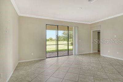 20635 Romagna Pl, Venice, FL 34293 - empty room with ornamental molding, baseboards, and light tile patterned floors