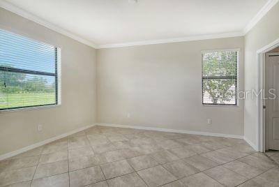 tiled spare room featuring ornamental molding