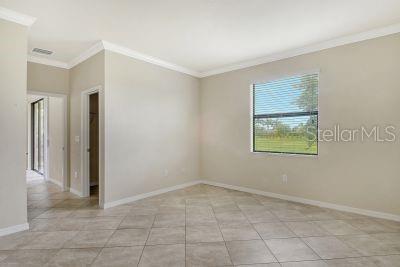 empty room featuring light tile patterned flooring and ornamental molding