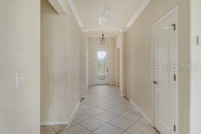 corridor featuring light tile patterned floors and ornamental molding