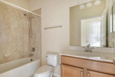 full bathroom featuring toilet, vanity, and tiled shower / bath