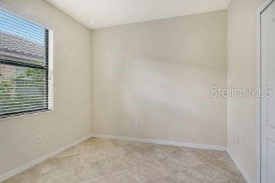 tiled spare room with a healthy amount of sunlight