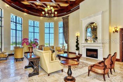 20635 Romagna Pl, Venice, FL 34293 - living area with a towering ceiling, coffered ceiling, a chandelier, beamed ceiling, and a fireplace
