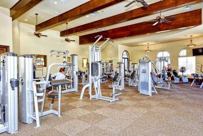 exercise room featuring ceiling fan and light colored carpet