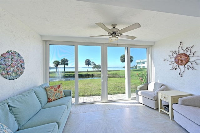 interior space with ceiling fan and a water view