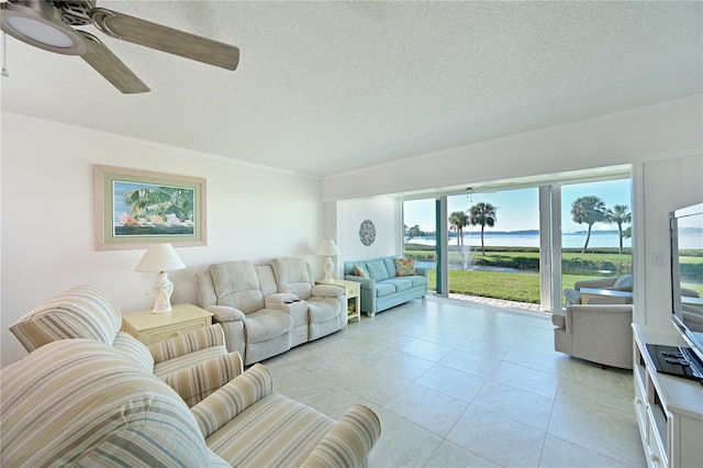 living room with ceiling fan, light tile patterned floors, and a textured ceiling