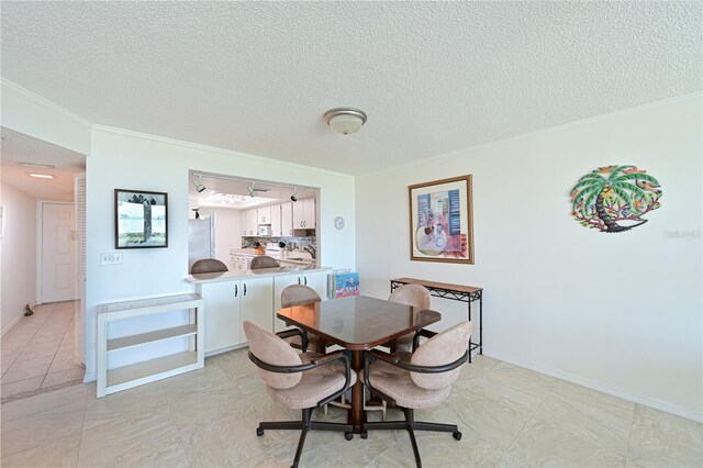 dining room with ornamental molding and a textured ceiling